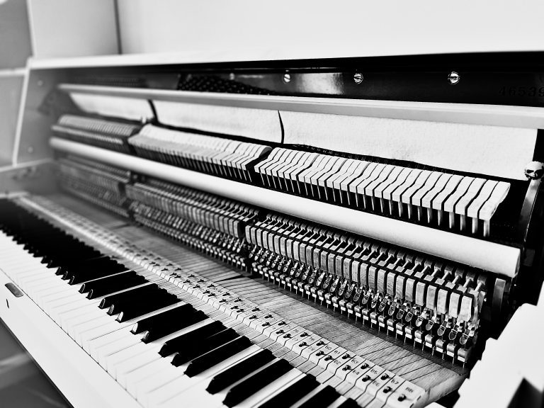 Piano droit sans bois, exposant la mécanique interne, représentant les compositions de piano solo d'Alexandre Dedola, compositeur pour films et projets visuels.
