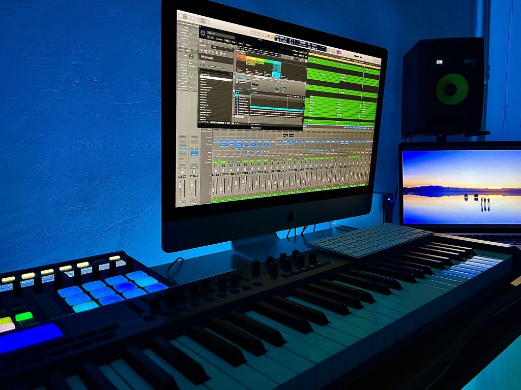 Studio de composition musicale avec ordinateur, clavier, enceinte et écran montrant un film en cours de composition par Alexandre Dedola, compositeur et sound designer.